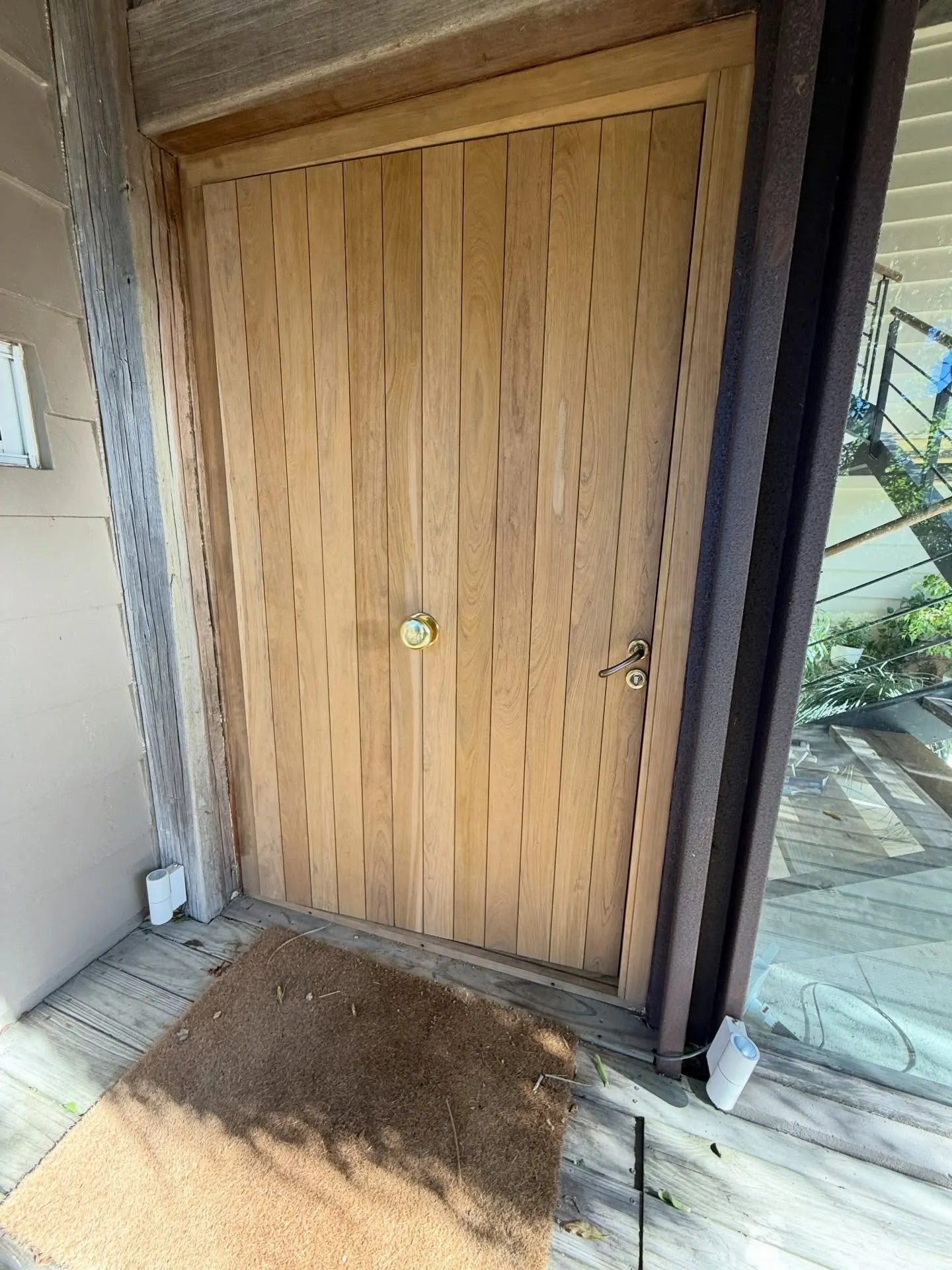 Renovación de acceso con puerta pivotante de lapacho — fotografía de obra