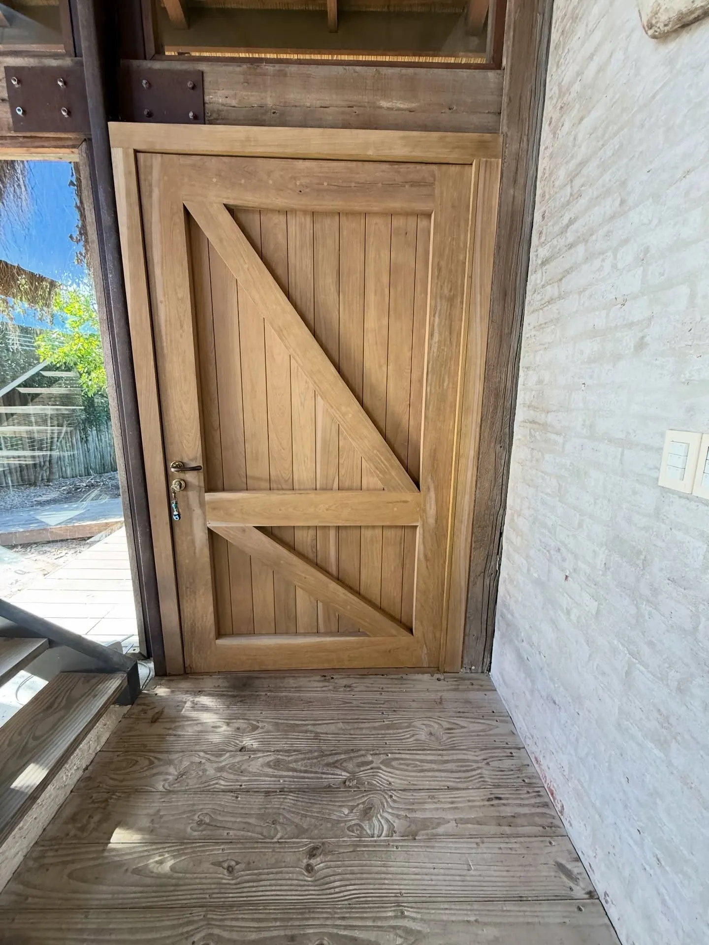 Renovación de acceso con puerta pivotante de lapacho — fotografía de obra