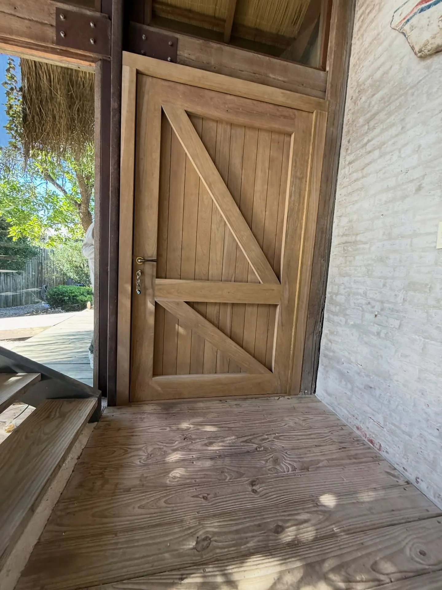 Renovación de acceso con puerta pivotante de lapacho — fotografía de obra