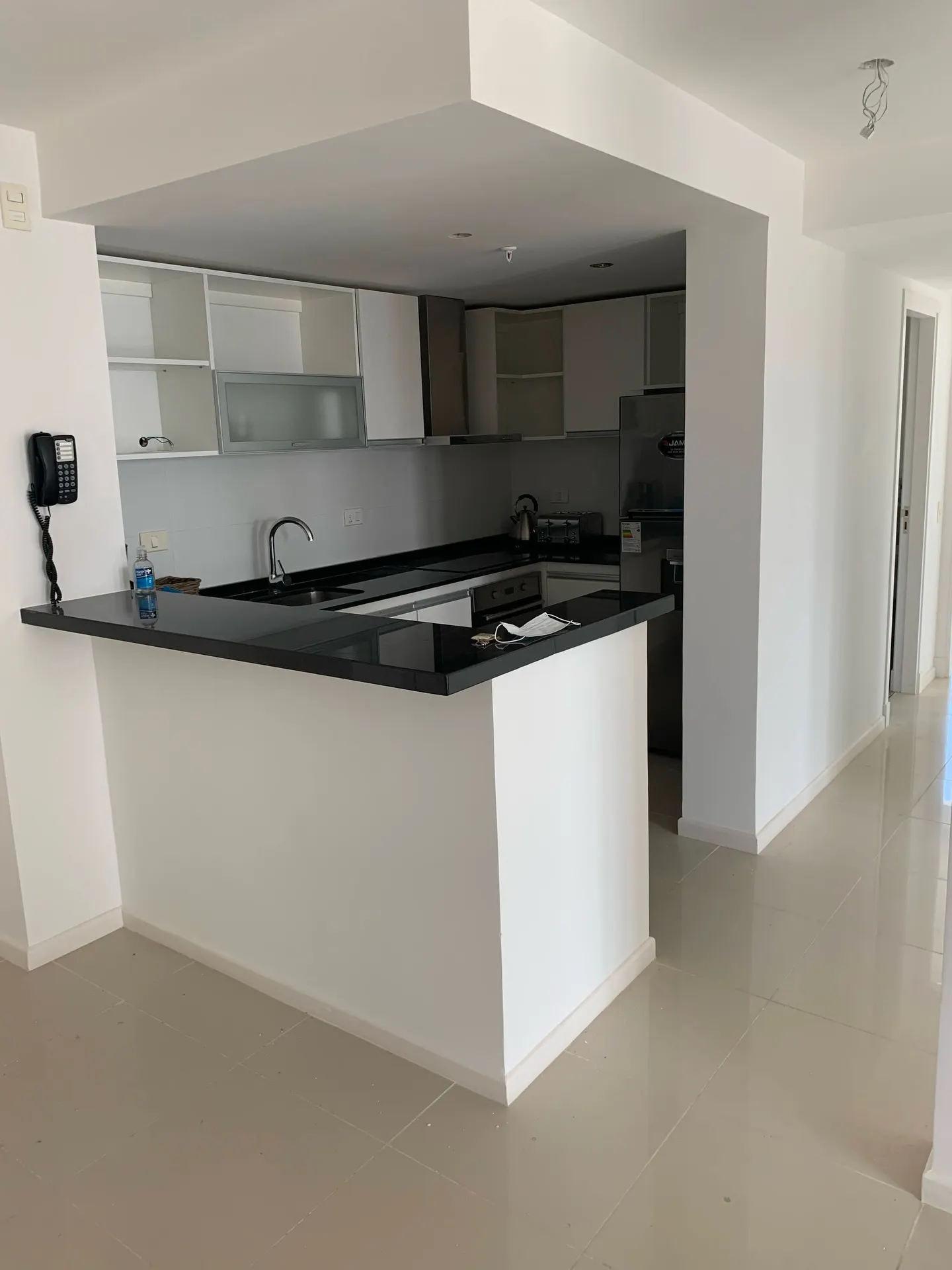 Isla de cocina revestida en piedra con mesada oscura, obra ejecutada por Unión Constructora
