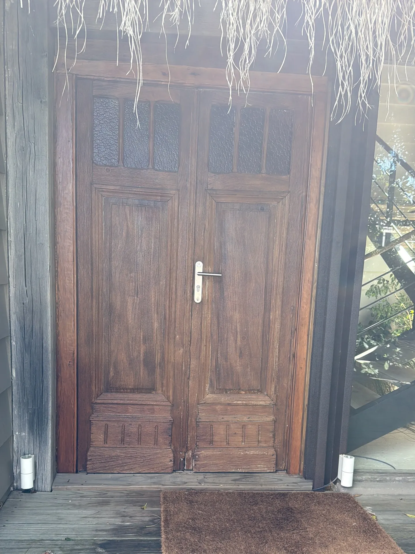 Renovación de acceso con puerta pivotante de lapacho — fotografía de obra